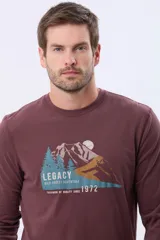 Remera de manga larga color bordó, con cuello redondo y estampado frontal de un paisaje montañoso con pinos y la palabra "LEGACY".