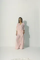 Pantalón palazzo de lino color blanco con rayas verticales rojas y cintura con cordón ajustable.