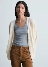 Cardigan de punto color crudo, con cuello en pico, cierre frontal de botones y diseño recto de manga larga.