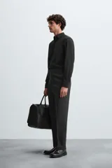 Camisa negra de corte slim fit, con cuello italiano y manga larga con puño abotonado. Cierre frontal de botonadura.