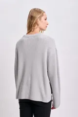 Sweater gris de punto inglés con cuello redondo y mangas largas.