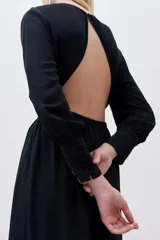 Vestido midi negro de viscosa, con escote redondo, espalda descubierta, mangas largas y frunces en cintura y cuello.