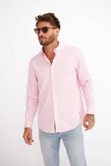 Camisa de hombre color crema, de corte clásico, con cuello abotonado y mangas largas.