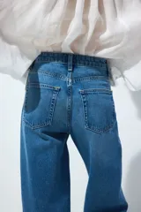Jean barrel de tiro alto en denim de algodón rígido, con diseño curvo en las piernas y corte de cinco bolsillos.