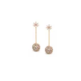 Caravanas colgantes de diseño moderno, compuestas por una pieza superior en forma de estrella y una esfera inferior texturizada, ambas adornadas con incrustaciones de zirconia. El diseño presenta una cadena fina que conecta ambos elementos, aportando movimiento y brillo.