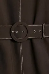Cuerpo de cuello redondo y manga corta, color marrón oscuro, con pespuntes en contraste y cinturón incorporado con hebilla forrada.