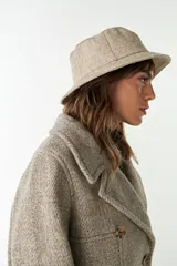 Sombrero tipo bucket de lana color beige con textura tweed.