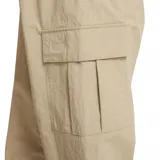 Pantalón cargo Nike de estilo deportivo, confeccionado en tejido ligero color beige. Presenta cintura elástica con cordón ajustable, bolsillos laterales tipo cargo y puños elásticos en los tobillos. Incluye el logo de la marca bordado en la parte superior.
