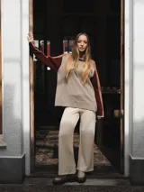 Buzo tejido de punto color crema con cuello alto y mangas largas con rayas horizontales en verde y lila.