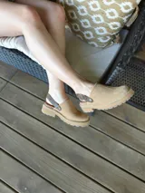 Zuecos de cuero color beige, con suela track y tira trasera ajustable.