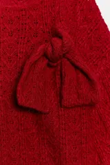 Jersey de punto de textura calada, color rojo, con cuello redondo, manga larga y detalle de lazo decorativo en el frente.