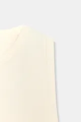 Top de punto color crema, sin mangas, con cuello redondo y corte ajustado.