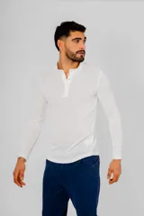 Remera de manga larga color negro, confeccionada en algodón, con cuello redondo y cierre frontal parcial con botones.