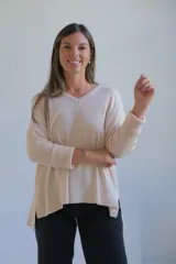 Sweater de punto en color crudo, con escote en V, mangas tres cuartos con puños acanalados y diseño holgado.
