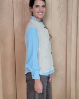 Chaleco de punto con diseño de trenzas, color gris oscuro, con cierre frontal de botones grandes y bolsillos laterales.