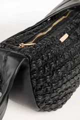 Cartera tipo riñonera negra con textura tejida y cierre superior con cremallera.
