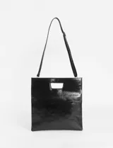 Sobre plegable de cuero vegano con diseño minimalista y abertura superior integrada. Incluye correa removible para usar como bandolera.