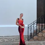 Vestido largo de microtul con estampado abstracto en tonos rojos y naranjas, con escote drapeado y tirantes finos.