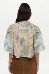 Blusa de algodón y seda con diseño estampado floreado, cuello mao, mangas anchas y detalles de mini volados y bordados en el pecho.