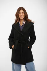 Tapado negro de corte cruzado con solapas amplias, capucha integrada y lazo ajustable en la cintura. Presenta cierre frontal con botones y bolsillos laterales.