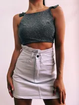 Crop top negro con textura brillante, breteles anchos con volados y espalda descubierta que se ata con lazos.