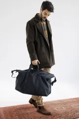 Abrigo de paño azul marino con doble botonadura, cuello con solapas y bolsillos laterales.