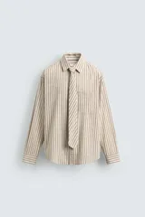 Camisa de corte relajado confeccionada en algodón, con estampado de rayas verticales. Presenta cuello solapa, manga larga con puños abotonados, bolsillo frontal y corbata integrada del mismo tejido.