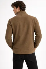 Buzo de polar negro con cuello alto y cierre frontal parcial, de manga larga y diseño holgado.