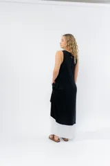 Vestido largo negro con base blanca, de corte suelto y sin mangas.