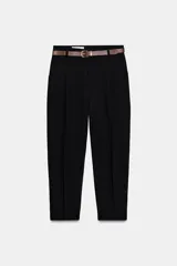 Pantalón tobillero negro de tiro medio con pinzas delanteras y bolsillos frontales. Incluye un cinturón delgado de cuero marrón con hebilla metálica dorada.