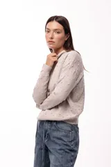 Sweater de punto con textura en relieve de pequeños puntos y diseño geométrico sutil. Presenta cuello redondo, mangas largas y puños y ruedo acanalados, con un calce relajado.