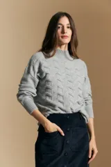 Sweater de punto gris con cuello alto y diseño geométrico en relieve. Presenta mangas largas con puños acanalados y un calce relajado.