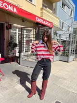 Pantalón de jean negro de tiro alto y corte recto, con detalles de roturas en las rodillas.