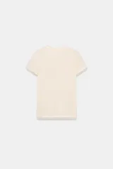 Camiseta de manga corta color marrón oscuro con textura acanalada, cuello redondo y bajo recto. Presenta un bajo superpuesto de tul o tela más clara, visible en el ruedo y en el cuello.