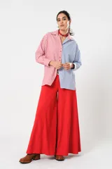 Camisa a rayas rojas y blancas en un lado y azules y blancas en el otro, con corte en A y abertura central con botonadura doble.