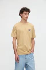 Remera marrón de manga corta con calce relajado, confeccionada en jersey de algodón pesado. Presenta una pequeña estampa con texto en el pecho y un diseño estampado en la espalda.