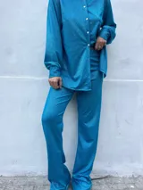 Pantalón turquesa de corte palazzo con cintura elastizada, confeccionado en tejido brillante.