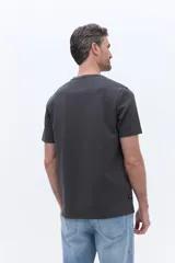 Remera de algodón con cuello redondo, manga corta y calce regular. Presenta un diseño minimalista con una pequeña estampa circular centrada en el pecho.