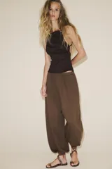 Top color fucsia de escote recto y tirantes finos, con detalle de pliegues y espalda descubierta. Cierre con lazadas en la espalda.