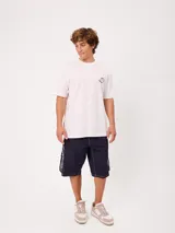 Remera Rusty de manga corta, color blanco, con ajuste holgado y gran estampa gráfica en la espalda de un mago surfeando entre olas.