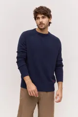 Sweater de punto color azul marino con cuello redondo, mangas largas y detalles acanalados en cuello, puños y ruedo.