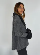 Saco marrón con rayas verticales en tonos beige, con cuello y puños de tejido rizado. Cierre frontal con botones.