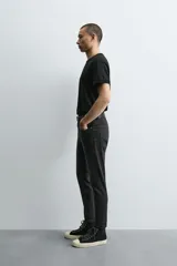 Jeans de hombre, corte skinny y largo cropped, color negro lavado. Presenta cinco bolsillos y cierre frontal con cremallera y botón.