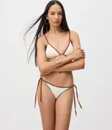 Bombacha de bikini confeccionada en microfibra texturada color marfil con ribetes marrones y celestes, modelo con ataduras laterales regulables.
