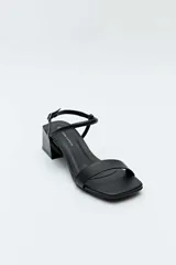 Sandalias Daniel Cassin modelo Nina, de color negro, con tira delantera ancha, puntera cuadrada, taco bajo bloque y tiras finas cruzadas en el talón con cierre de hebilla ajustable.