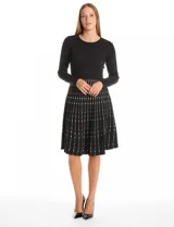 Vestido midi de punto con cuerpo liso negro de manga larga y falda acampanada con patrón geométrico vertical en contraste. Presenta escote redondo a la base y diseño entallado.