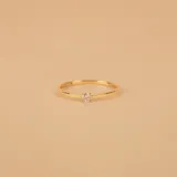 Anillo solitario de oro amarillo 18k con un brillante central engarzado en cuatro puntas y banda fina.
