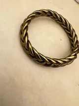 Pulsera de resina flexible con diseño trenzado y acabado brillante, con relleno de lámina metálica en tonos dorados, plateados y cobrizos.
