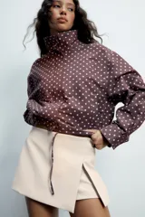 Falda pantalón de tiro medio color negro, con detalle de abertura en el delantero y cierre lateral con cremallera oculta.