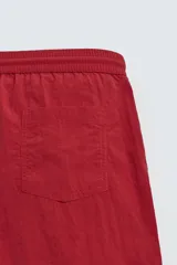 Bañador de hombre color azul marino, confeccionado en tejido técnico, con cintura elástica ajustable mediante cordón. Presenta bolsillos laterales y un bolsillo trasero de plastrón. Incluye forro interior.